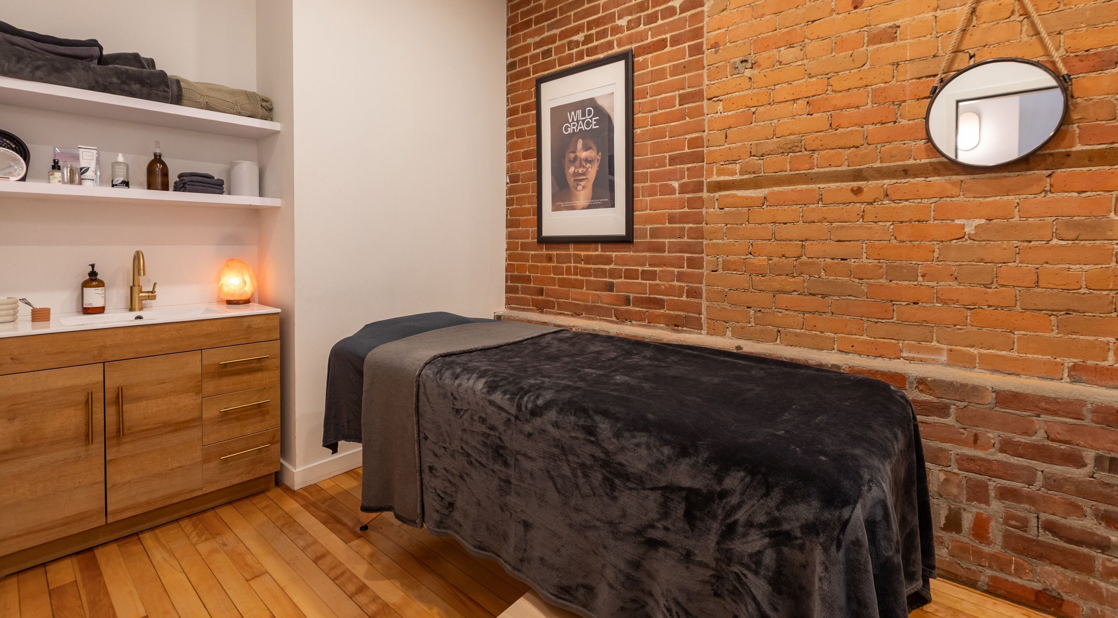 Salle de soins accueillante à La Loge Soins & Esthétique, Montréal, Québec, CA, avec décoration en briques.