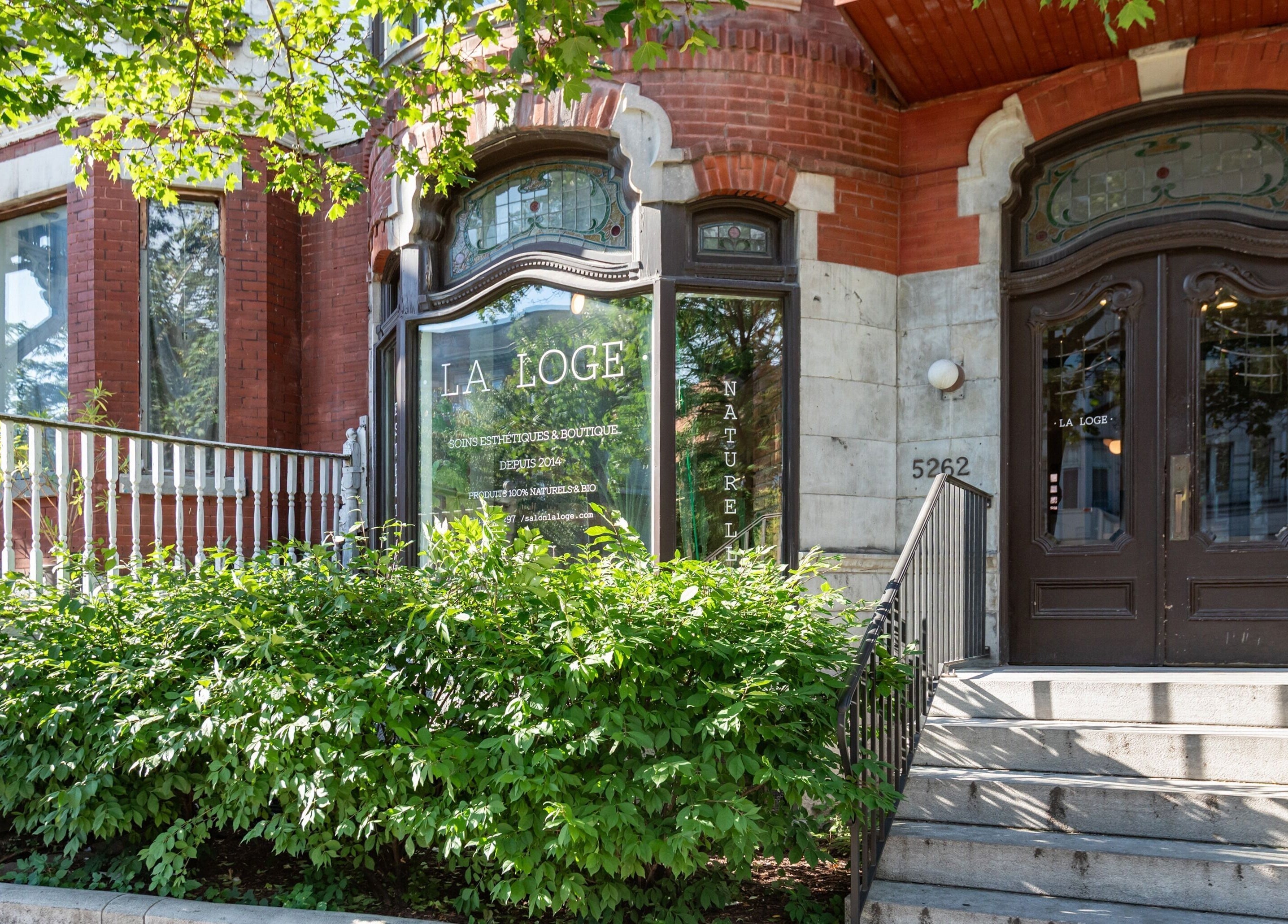 Entrée accueillante de La Loge Soins & Esthétique à Montréal, Québec, CA, entourée de verdure luxuriante.