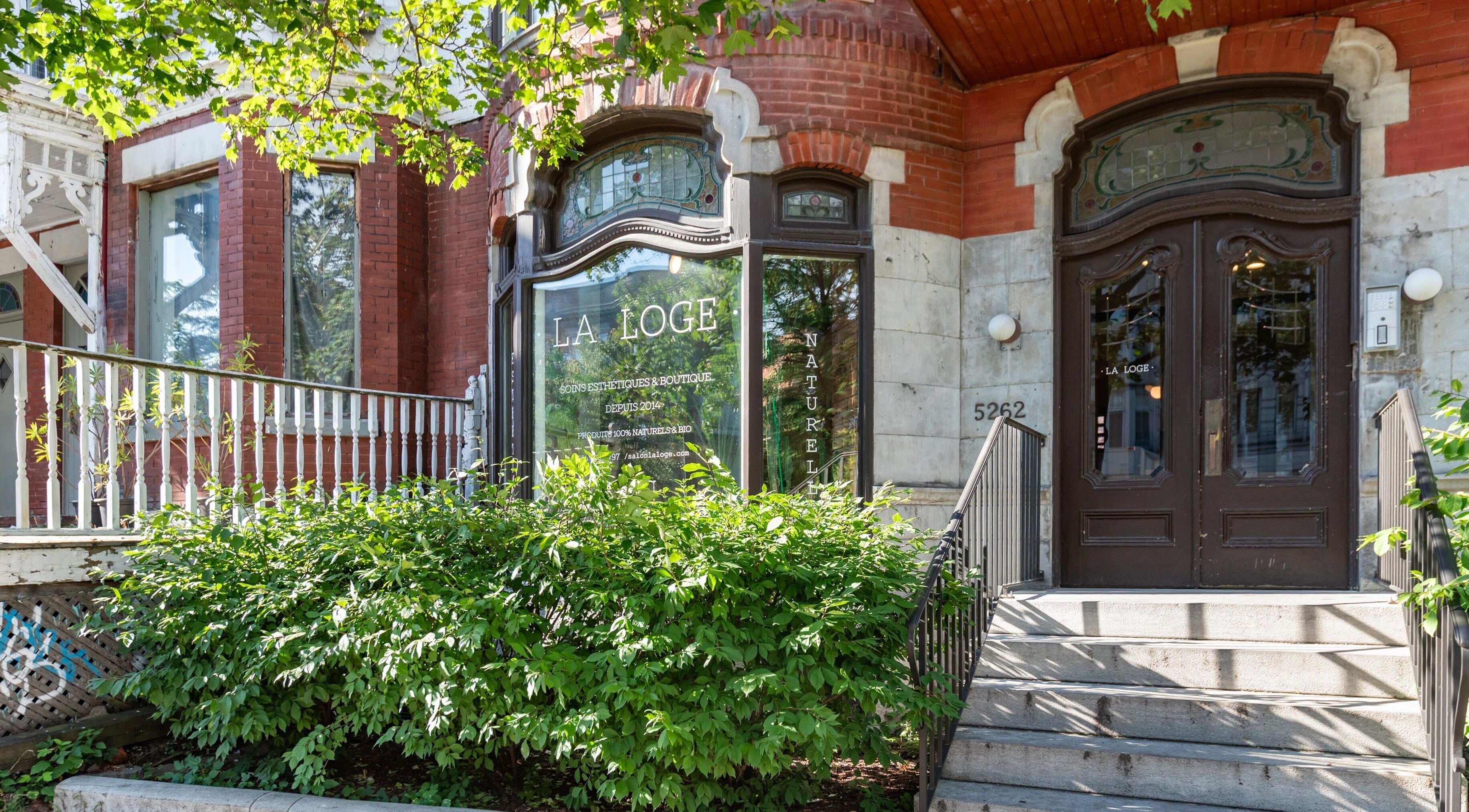 Entrée accueillante de La Loge Soins & Esthétique à Montréal, Québec, CA, entourée de verdure luxuriante.