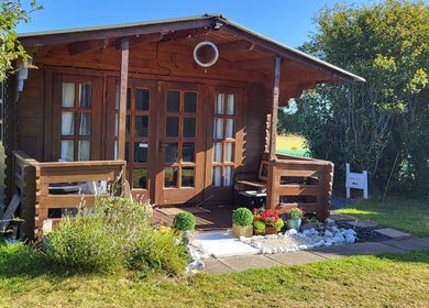 The Healing Room, a charming wooden cabin in Dublin, Dublin, IE surrounded by greenery and flowers.