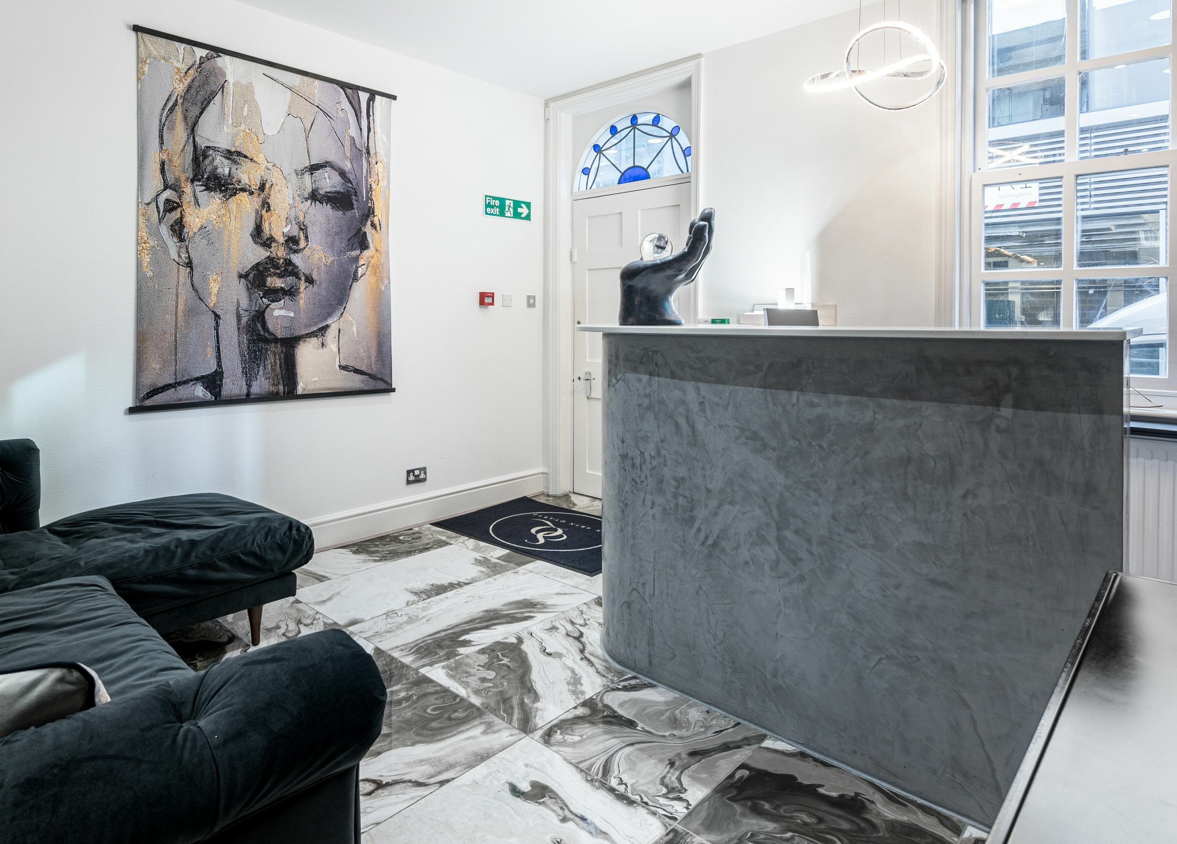 Reception area of The Skin Quartz, Manchester, England, featuring chic artwork and modern decor.