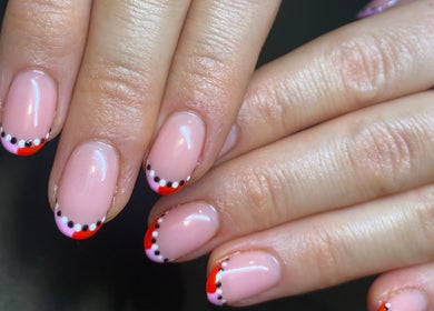 Stylish nail art with dots and red tips at Fiona Watton Beauty, Bude, England, GB.
