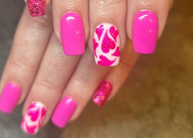 Vibrant pink nail art with heart designs at Fiona Watton Beauty, Bude, England, GB.