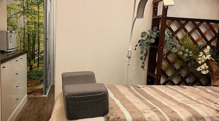 Relaxing treatment room at PUREGLAM BEAUTY in Melbourne, Victoria, AU, featuring a serene forest mural and cozy setup.