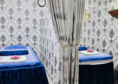 Elegant massage room at Thai Rose Massage Center, Ajman, AE, with twin massage tables and floral decor.