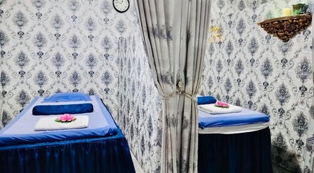 Elegant massage room at Thai Rose Massage Center, Ajman, AE, with twin massage tables and floral decor.