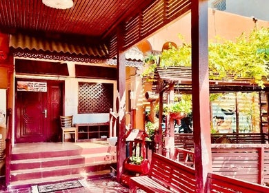 Charming entrance of Thai Rose Massage Center in Ajman, AE, surrounded by lush greenery and inviting decor.