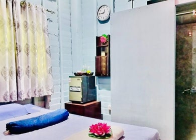 Relaxing massage room at Thai Rose Massage Center, Ajman, AE, featuring cozy bed and soothing ambiance.