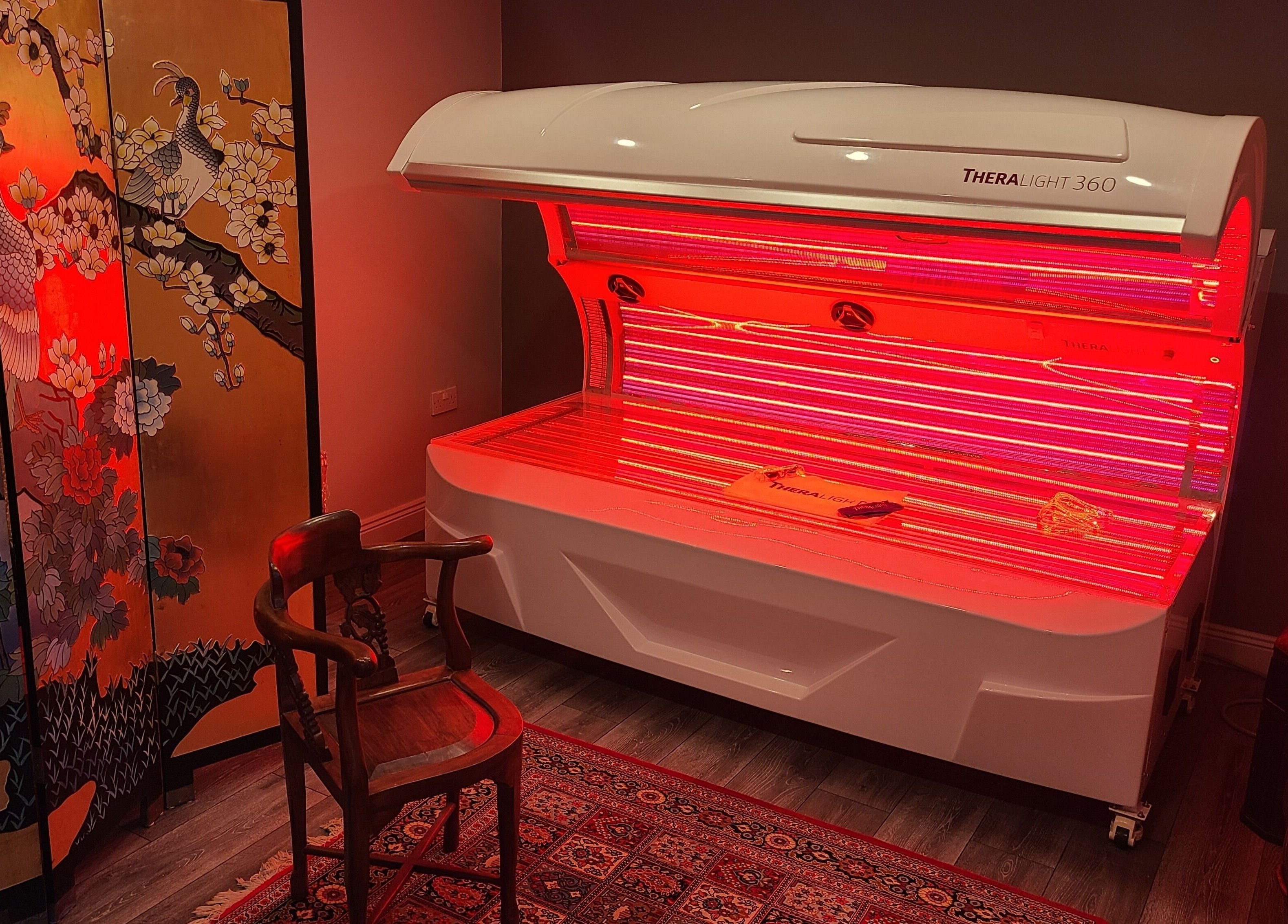 Relaxing red light therapy room at Phoenix Wellness, Gorey, Ireland, IE, featuring a decorative panel.