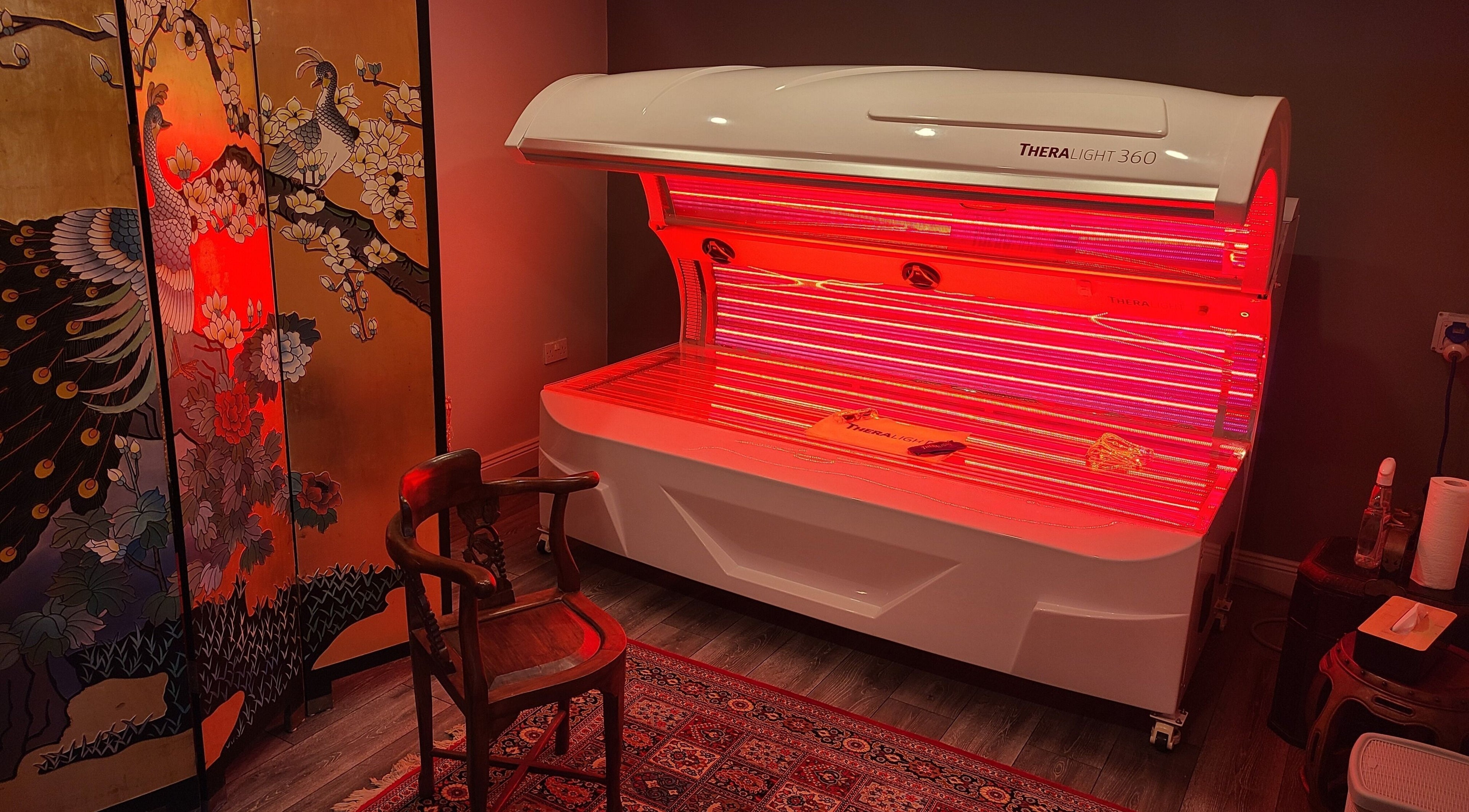 Relaxing red light therapy room at Phoenix Wellness, Gorey, Ireland, IE, featuring a decorative panel.