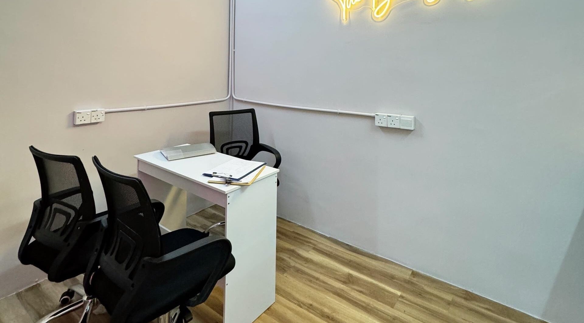 Helena Beauty Spa HQ, Kuala Lumpur, MY: sleek consulting room with chairs and desk under soft lighting.