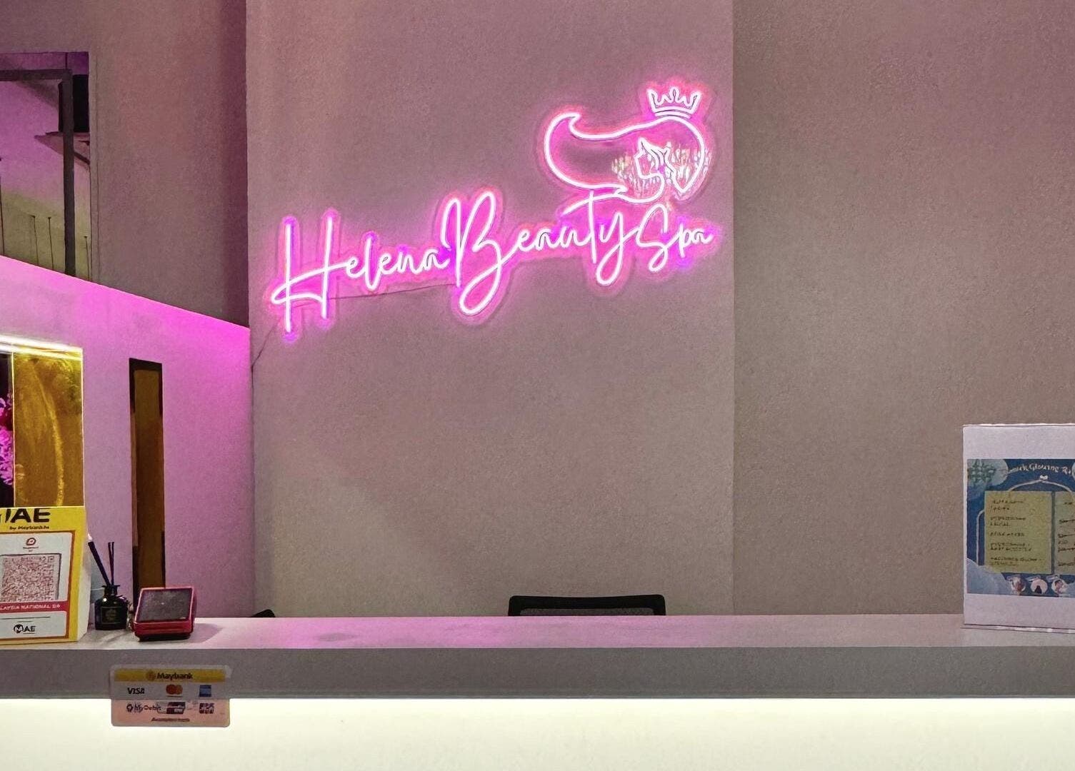 Reception desk at Helena Beauty Spa HQ, Kuala Lumpur, with vibrant neon signage.