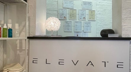 Reception desk at Elevate, Ripon, England, GB, with certificates and products displayed prominently.