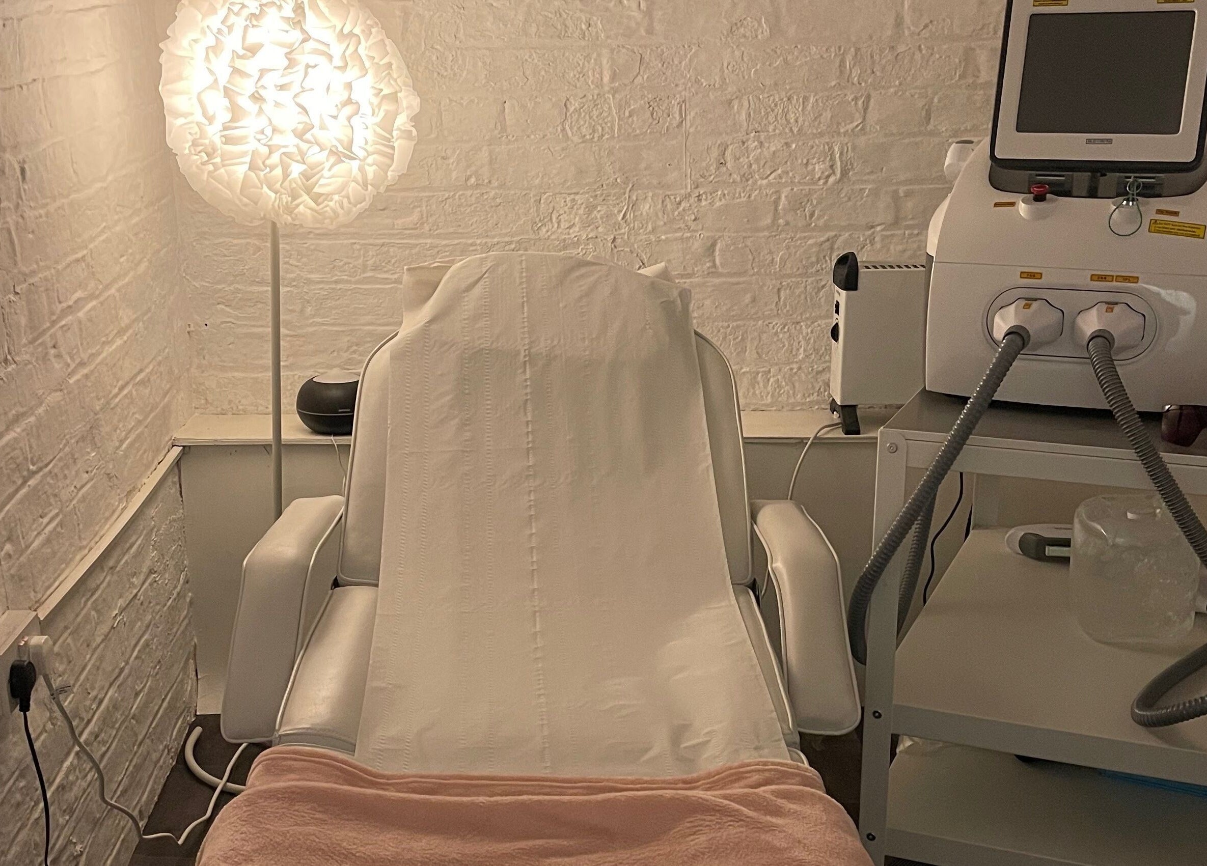 Cozy treatment room at Elevate, Ripon, England, GB featuring a white chair and soft lighting.