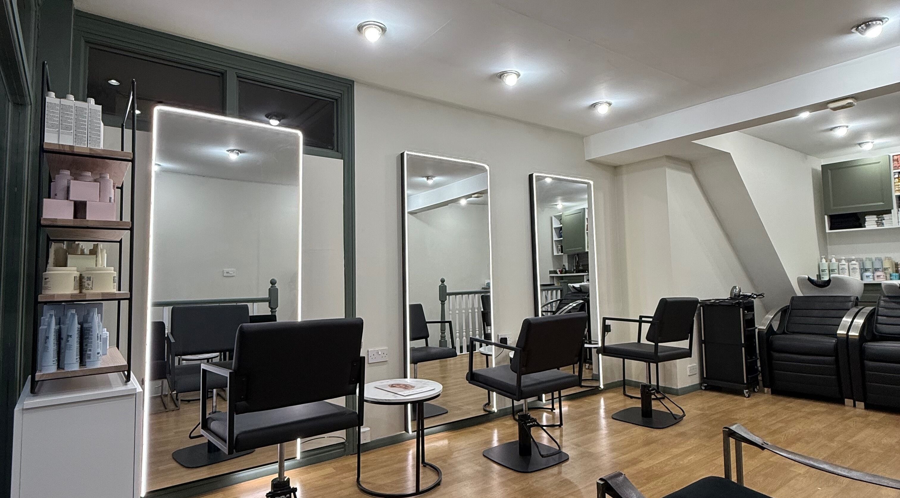 Modern interior of Muse Hair Studio in Twickenham, England, GB with stylish chairs and mirrors.