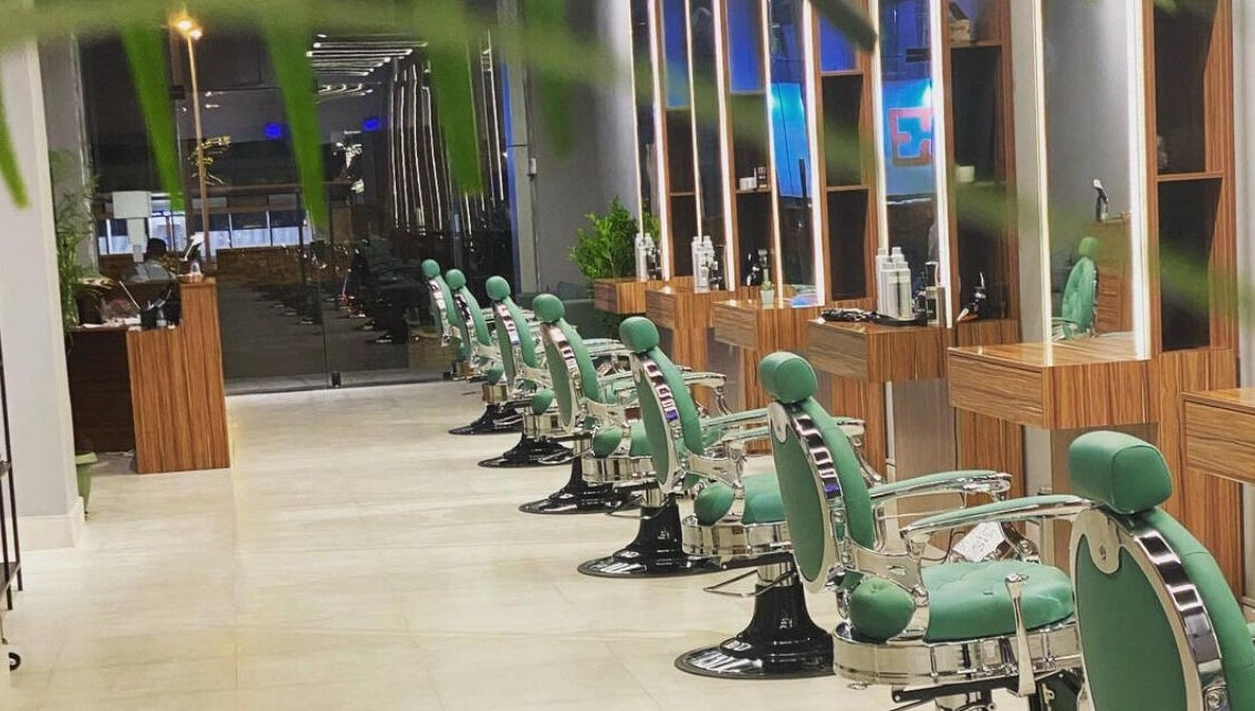 Modern green barber chairs at Degrees Barbershop, Riyadh, SA, showcasing sleek interior design.