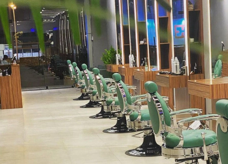 Modern green barber chairs at Degrees Barbershop, Riyadh, SA, showcasing sleek interior design.