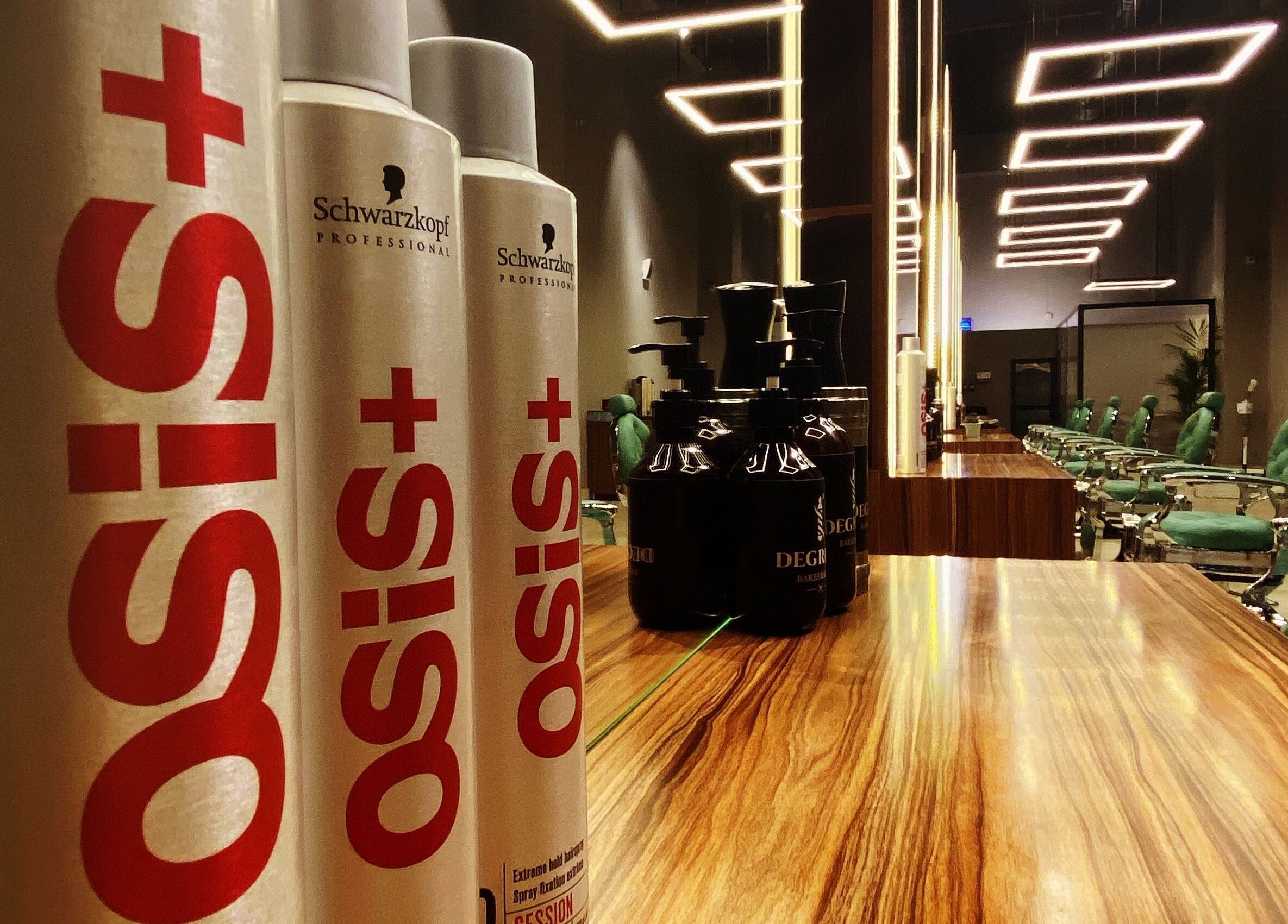 Modern interior of Degrees Barbershop, Riyadh, SA with stylish chairs and hair products.