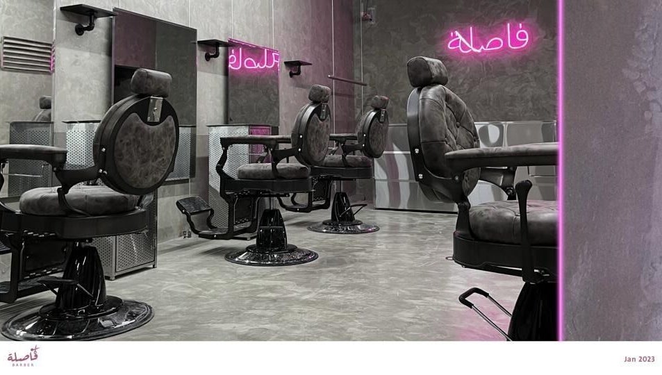 Modern barber chairs at Comma Barber, Riyadh, Riyadh Province, SA with stylish neon lighting.