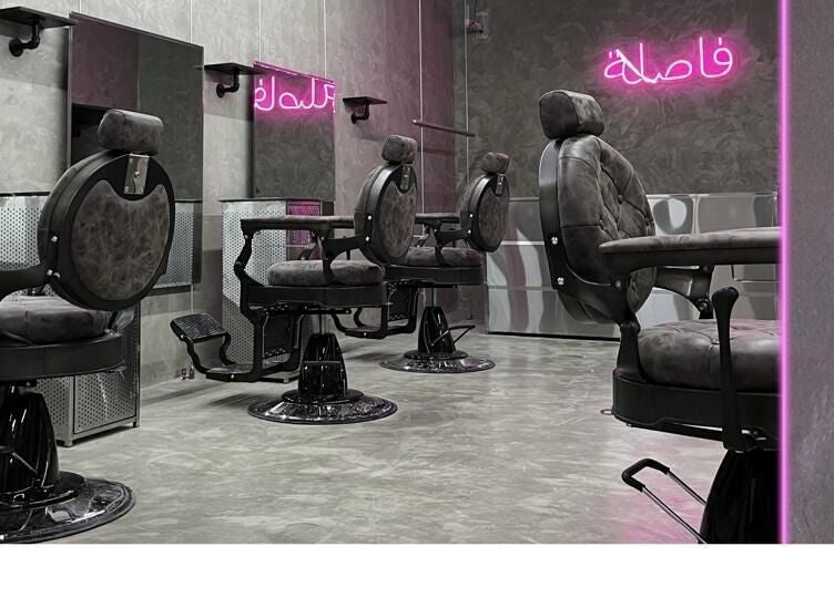 Modern barber chairs at Comma Barber, Riyadh, Riyadh Province, SA with stylish neon lighting.