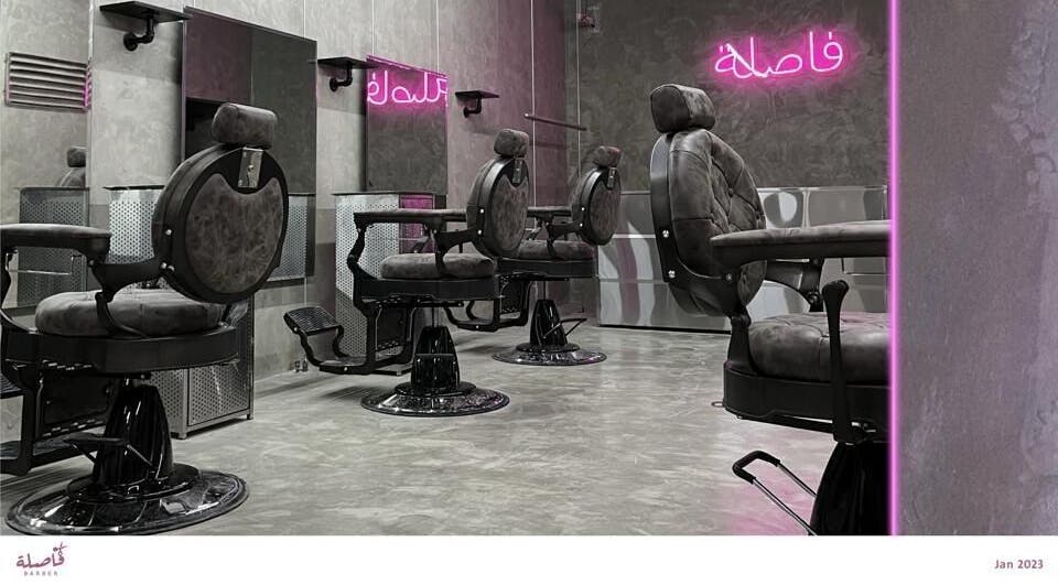 Modern barber chairs at Comma Barber, Riyadh, Riyadh Province, SA with stylish neon lighting.