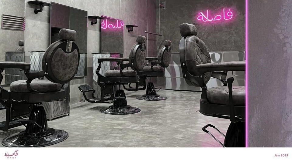 Modern barber chairs inside Comma Barber, Riyadh, Riyadh Province, SA, with stylish neon accents.