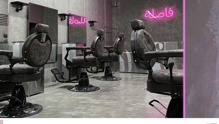 Chic interior of Comma Barber in Riyadh, Riyadh Province, SA, featuring stylish barber chairs and glowing neon lights.