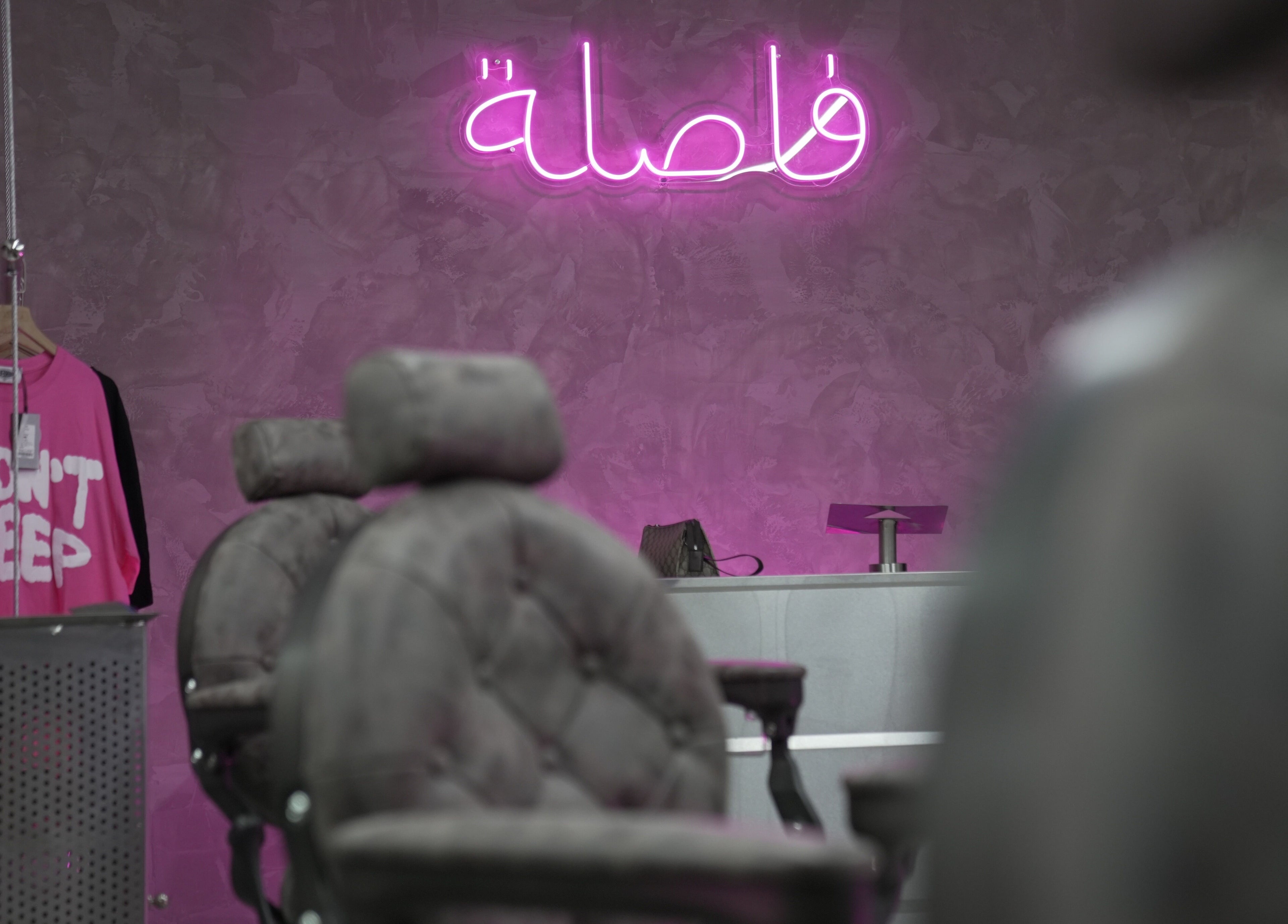 Comma Barber's trendy interior with pink neon sign in Riyadh, Riyadh Province, SA.