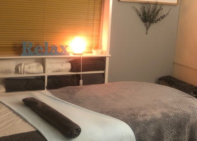 Relaxing massage room at Bodycare by Drea in Newtown, Wales, GB with ambient lighting and soft towels.