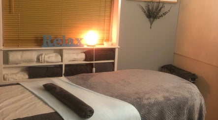 Relaxing massage room at Bodycare by Drea in Newtown, Wales, GB with ambient lighting and soft towels.