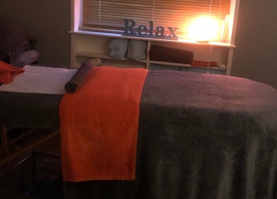 Warm-lit massage room at Bodycare by Drea in Newtown, Wales, GB, featuring a cozy table with plush towels.