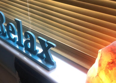 Relax sign and glowing salt lamp at Bodycare by Drea in Newtown, Wales, GB, promoting a calming atmosphere.