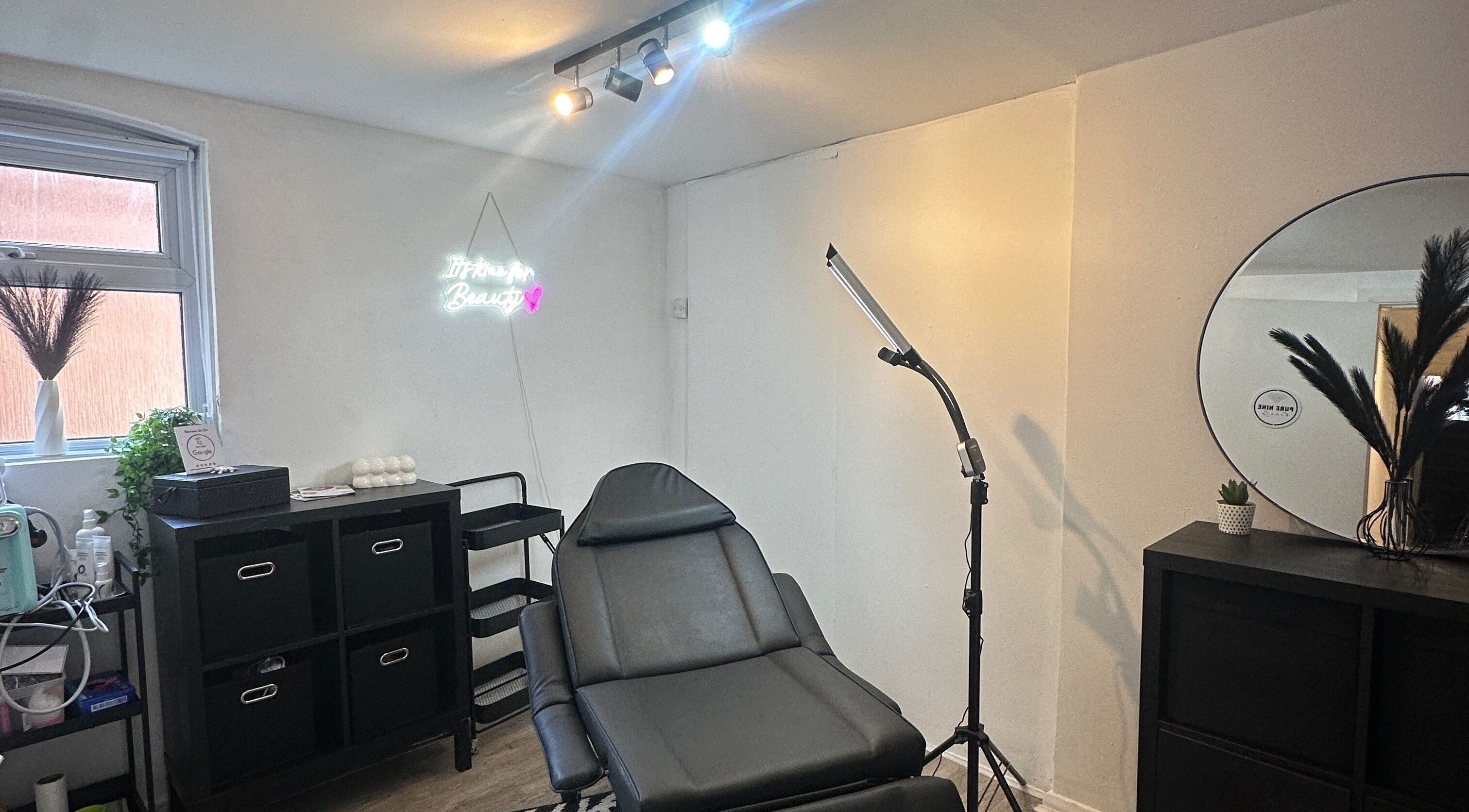 A relaxing treatment room at Pure Nine Beauty (Harborne), Birmingham, England, GB featuring a comfy chair and decor.
