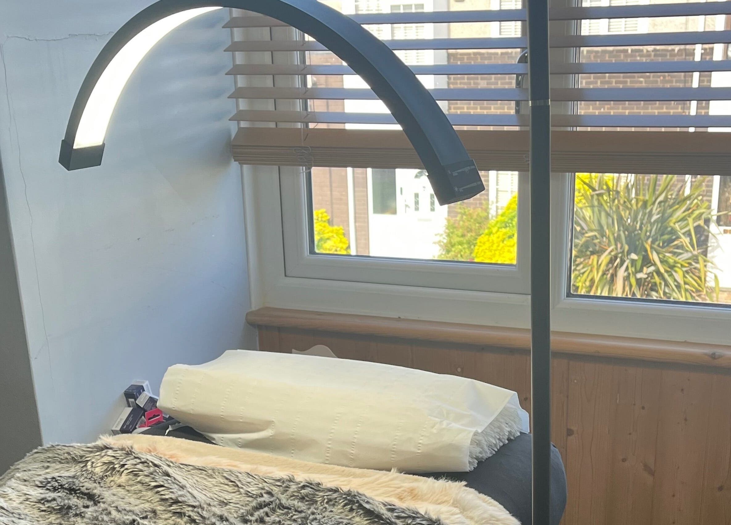 Relaxing treatment area at Maison de Maya, Basildon, England, GB with soft lighting and comfy bed.