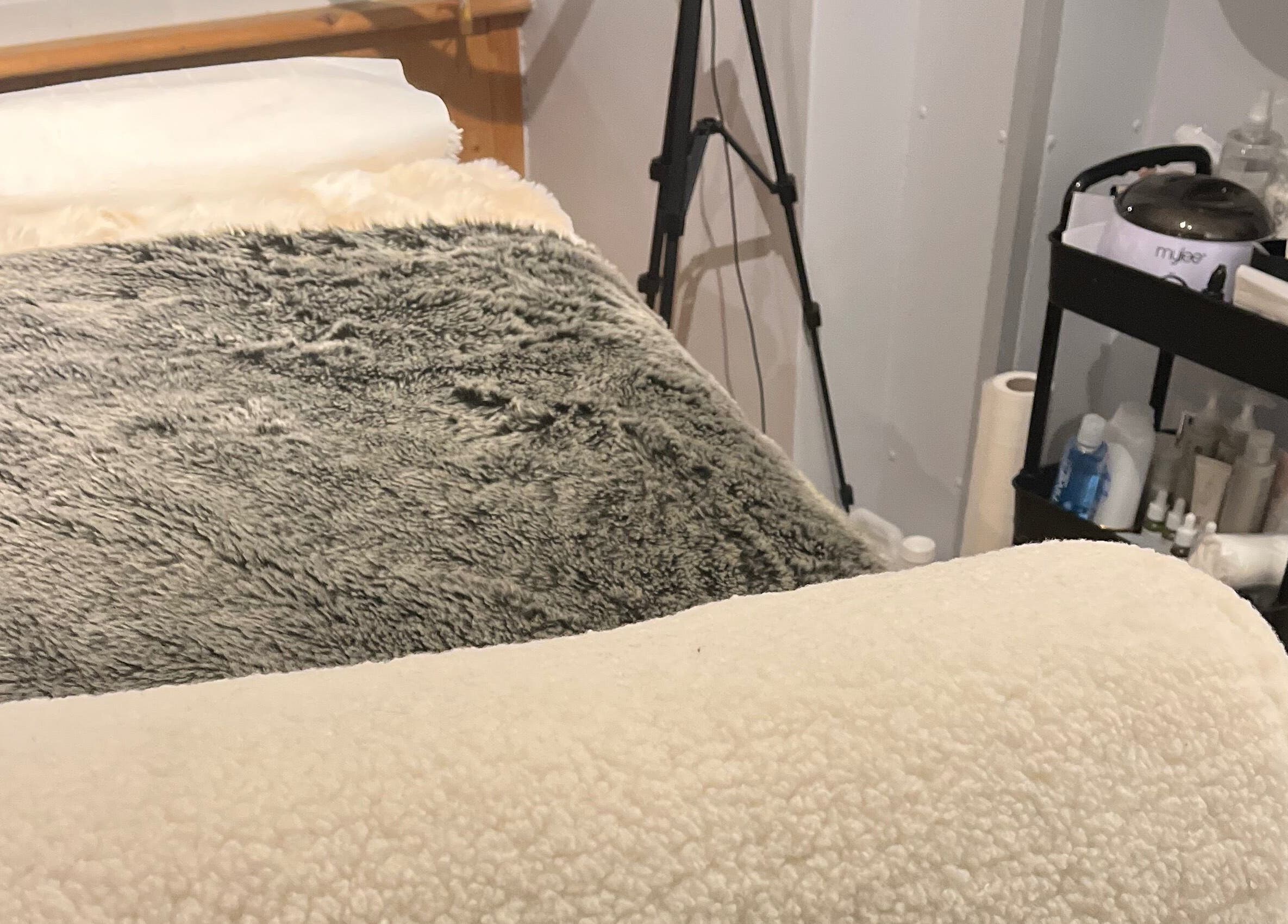 Cozy treatment bed with soft throws at Maison de Maya, Basildon, England, GB.