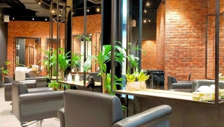 Chic salon interior at C.Michael London in Kuala Lumpur, featuring modern black chairs and lush plants.