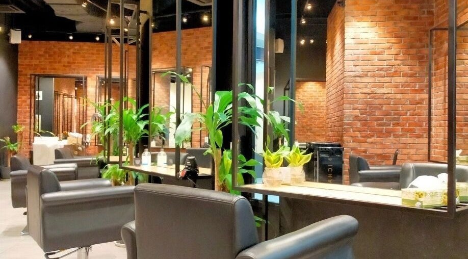 Chic salon interior at C.Michael London in Kuala Lumpur, featuring modern black chairs and lush plants.