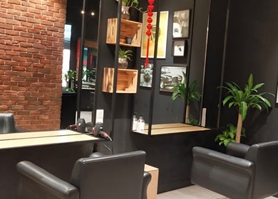Stylish interior of C.Michael London salon in Kuala Lumpur, featuring sleek chairs and lush plants.