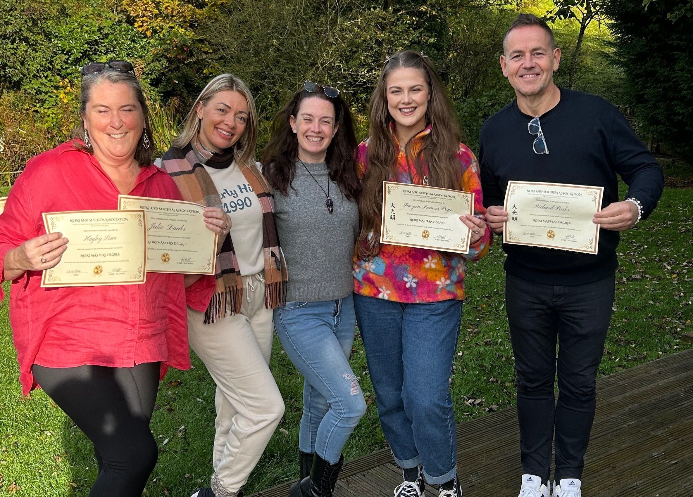 Group celebrating certificate awards at The Indigo Life, Rugeley, England, GB outdoors.