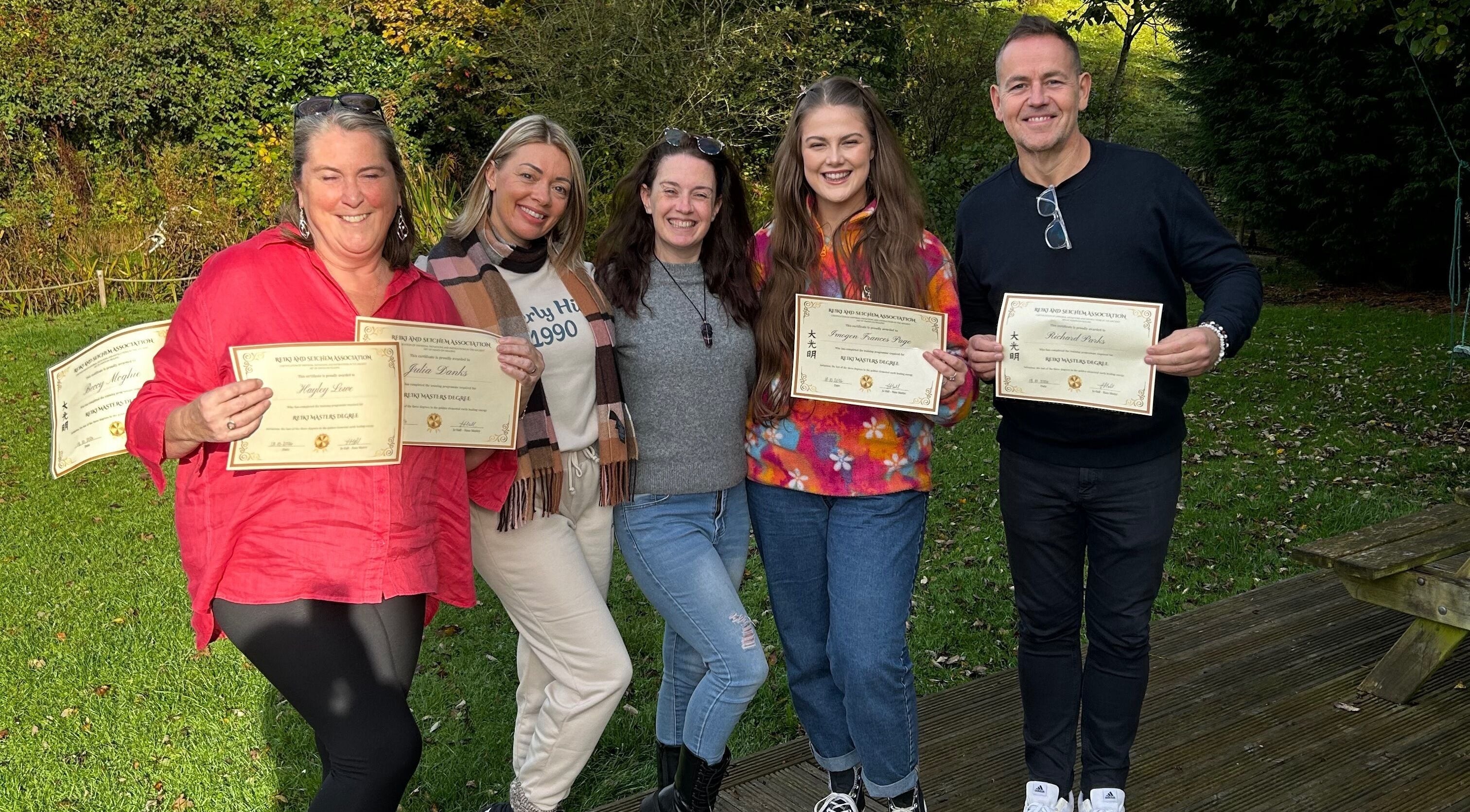 Group celebrating certificate awards at The Indigo Life, Rugeley, England, GB outdoors.