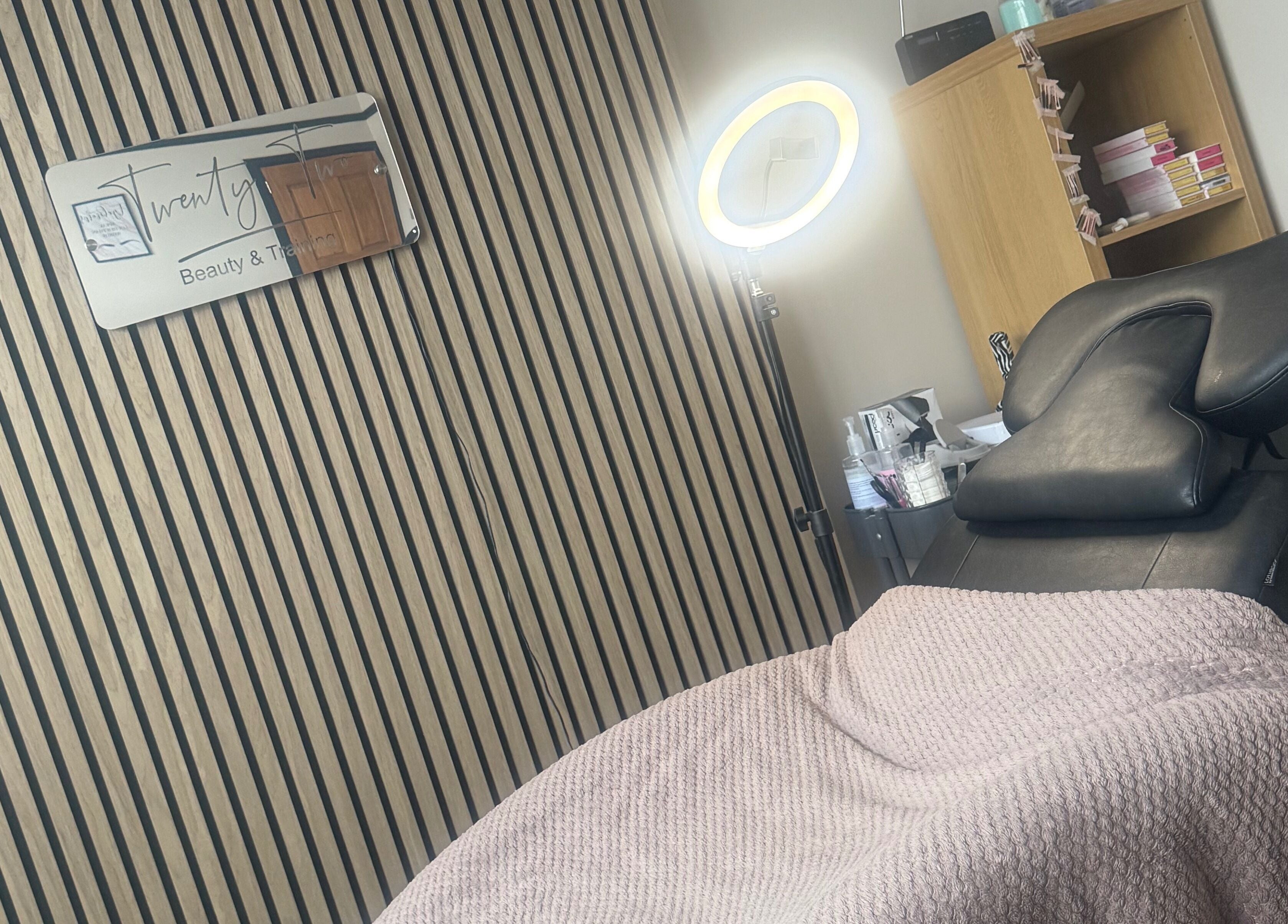 Cozy treatment area at Twenty Two Beauty and Training in Ripley, England, GB with a massage chair and ring light.