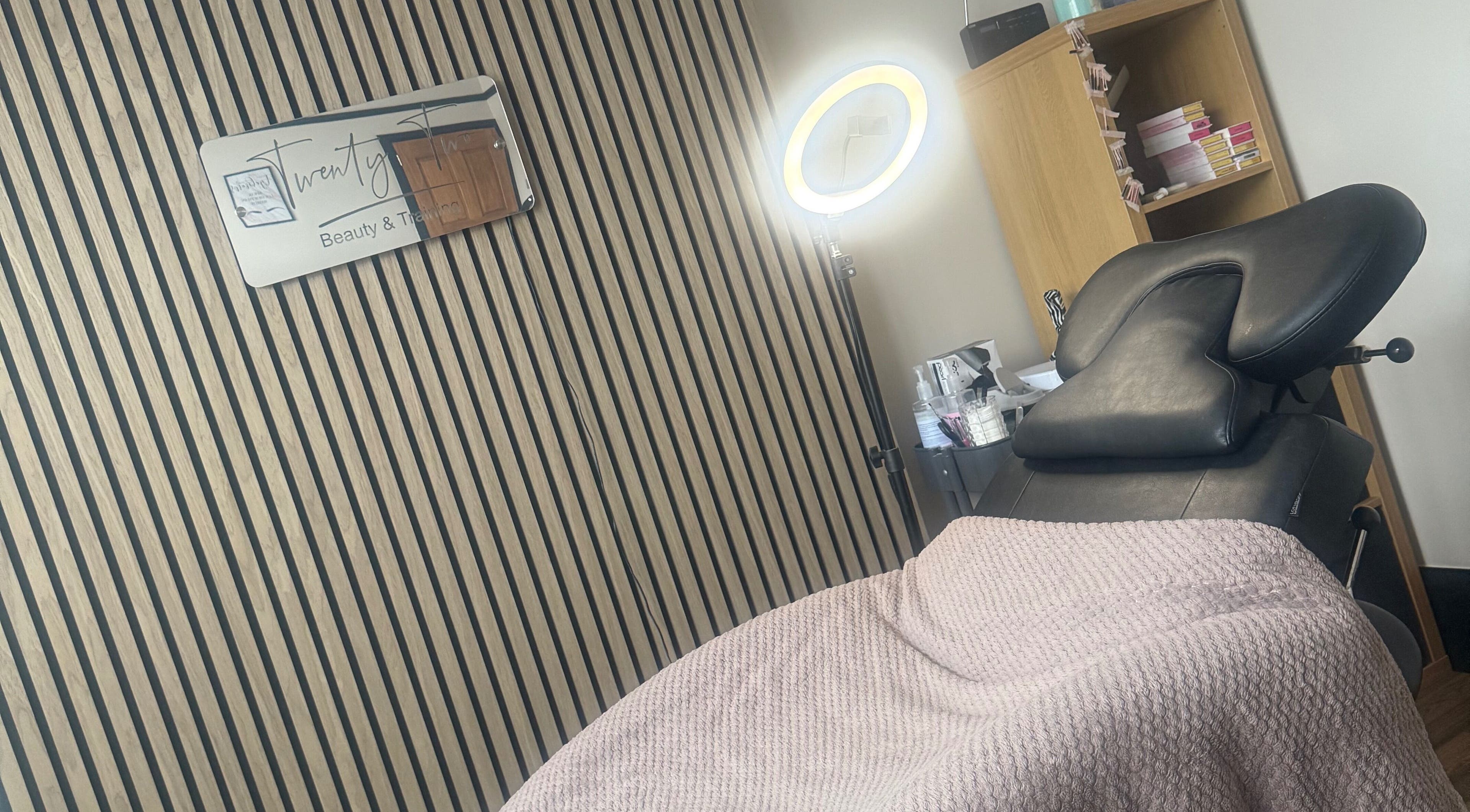 Cozy treatment area at Twenty Two Beauty and Training in Ripley, England, GB with a massage chair and ring light.