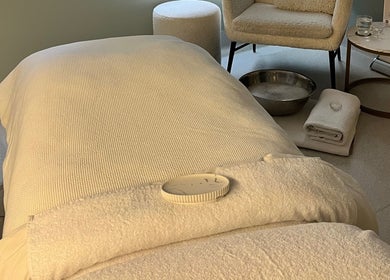 Relaxing treatment room at Exhale Holistic Skin, Bentleigh East, Victoria, AU featuring a massage bed and cozy chair.