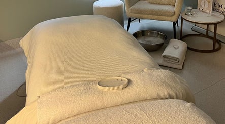 Relaxing treatment room at Exhale Holistic Skin, Bentleigh East, Victoria, AU featuring a massage bed and cozy chair.