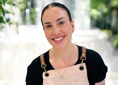 Smiling specialist at Exhale Holistic Skin in Bentleigh East, Victoria, AU, surrounded by lush greenery.