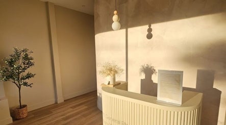Bright, minimalist reception at Exhale Holistic Skin, Bentleigh East, Victoria, AU with warm sunlight illuminating decor.
