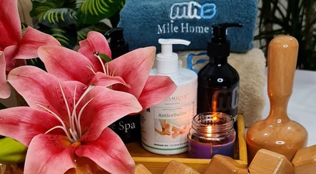 Relaxing spa essentials at Mile Home Spa in Abu Dhabi, Abu Dhabi, AE, featuring flowers, oils, and candles.