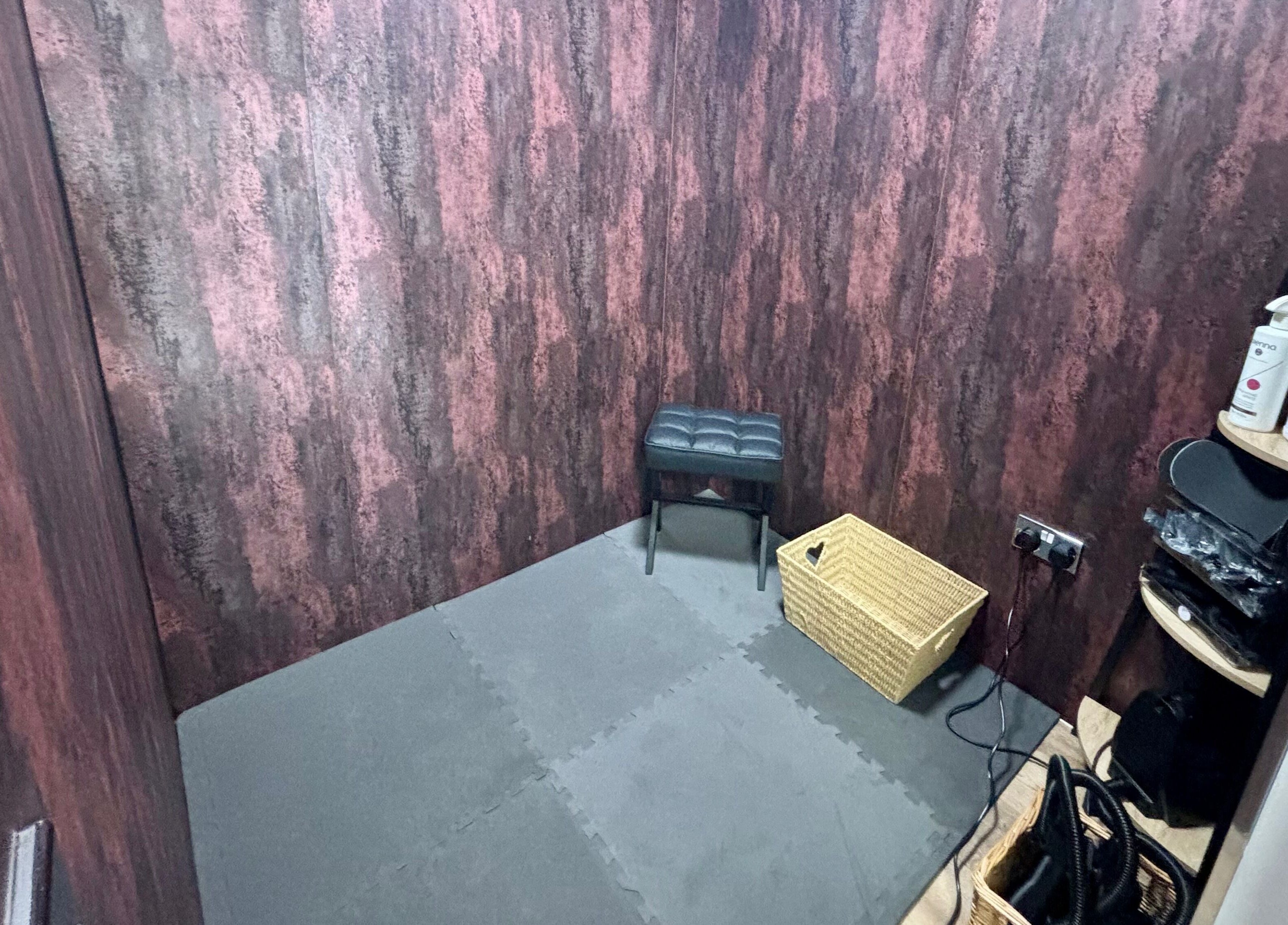 Compact, stylish treatment room at Elements of Beauty, Fallin, Scotland, GB, with seating and product shelves.