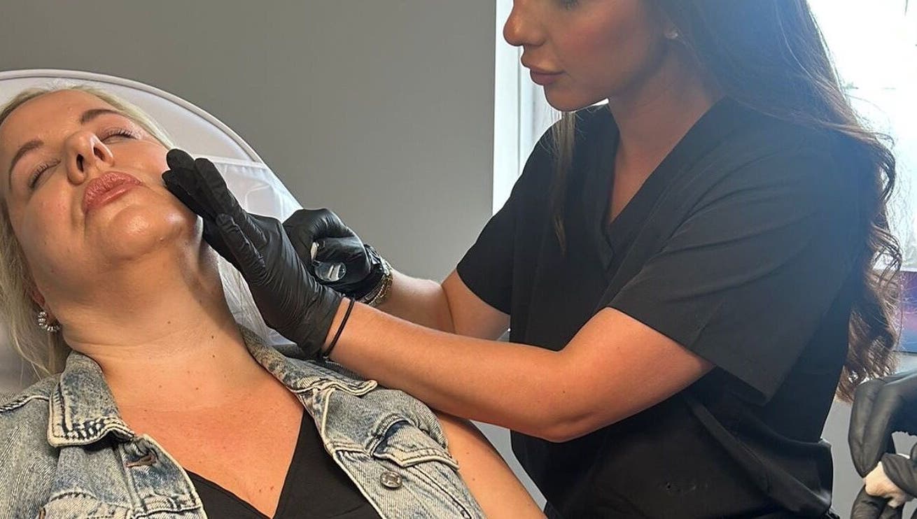 Aesthetic professional treating client at Clinic 01, East Kilbride, Scotland, GB.