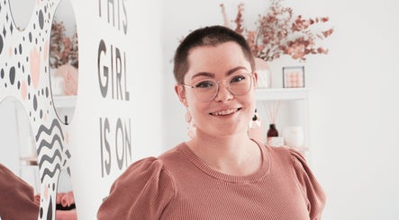 Visitor at Girl On Fire Beauty, Taylor, ACT with artful decor as backdrop.